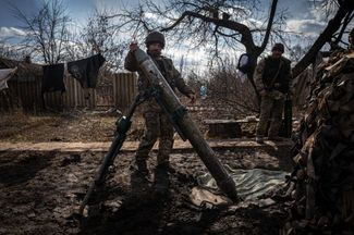 Военнослужащий 24-й отдельной механизированной бригады заряжает миномет боеприпасами