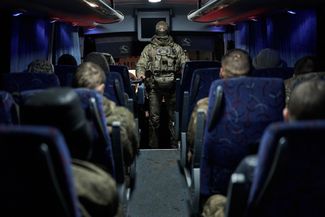 Российские военнослужащие в автобусе — их везут к месту обмена пленными