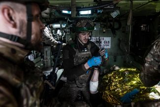 Украинские парамедики оказывают помощь раненому в эвакуационной бронемашине, которая пытается покинуть зону боевых действий у Бахмута. Все дороги находятся под огнем артиллерии и противотанковых ракет российских сил