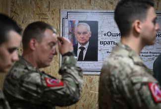 Церемония награждения российских военных. На стене висит плакат с фотографией нового министра обороны РФ Андрея Белоусова и его цитатой: «Ошибаться можно, врать нельзя».