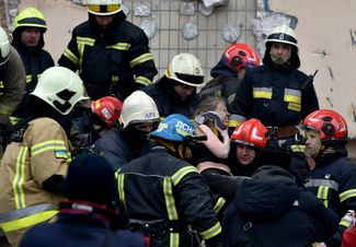 Спасатели выносят жительницу дома на набережной Победы из-под завалов ее разрушенной квартиры