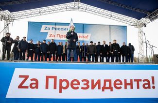 Глава Якутии Айсен Николаев (в центре) выступает на сцене во время акции в поддержку Владимира Путина и армии РФ после начала войны с Украиной