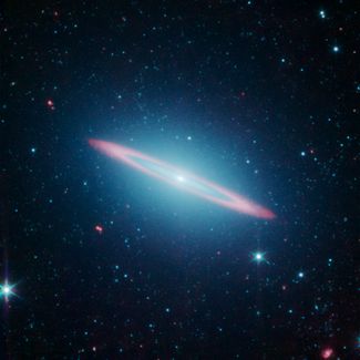 Галактика Сомбреро в созвездии Девы, удаленная от Земли на 29 миллионов световых лет. Данные, полученные «Спитцером», позволили установить, что объект представляет собой две галактики — эллиптическую и находящуюся внутри нее плоскую спиральную. 