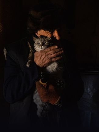67-летний Игорь обнимает свою кошку. Он показывает журналистам свой дом в Житомире, разрушенный в результате российских бомбардировок. 20 марта 2022 года