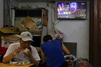 Посетители ресторана в Тайбэе. На заднем фоне — новостной выпуск с участием Нэнси Пелоси. Тайвань, 1 августа 2022 года