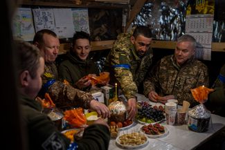 Командующий Объединенными силами ВСУ генерал-лейтенант Сергей Наев (справа) и украинские военнослужащие во время пасхальной трапезы на оборонительном посту в Киеве