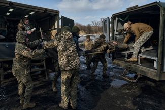 Военные врачи ВСУ несут на носилках раненного в бою солдата