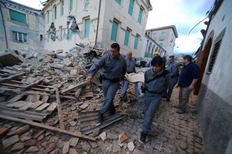 Спасатели несут пострадавшего при землетрясении