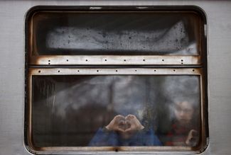 Дети в окне украинского поезда, прибывающего на вокзал в Перемышле изо Львова. Польша, 7 марта 2022 года