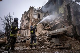 Сотрудники Государственной службы Украины по чрезвычайным ситуациям (ГСЧС) тушат пожар в разрушенном в результате российского удара здании в Кривом Роге