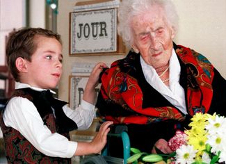 Пятилетний мальчик по имени Томас дарит цветы 122-летней Жанне Кальман, 12 февраля 1997 года. Именно Кальман, скончавшейся в том же 1997-м, принадлежит документально подтвержденный мировой рекорд продолжительности жизни.