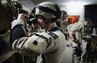 Боец «морских котиков» проверяет прибор ночного видения перед операцией в иракской Фаллудже в июле 2007 года.