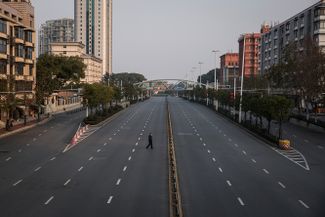 Мужчина переходит пустое шоссе в китайской Ухани во время локдауна в феврале 2020 года. К этому моменту коронавирус уже перекинулся на другие страны и началась пандемия. 3 февраля 2020 года