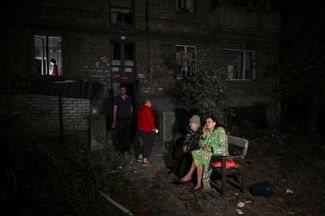 Жители Запорожья у поврежденного российским авиаударом дома, 23 сентября 2024 года