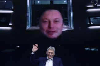 Пресс-секретарь президента России Дмитрий Песков на форуме «Новое знание». На экране — глава компаний Tesla и SpaceX Илон Маск. 21 мая 2021 года