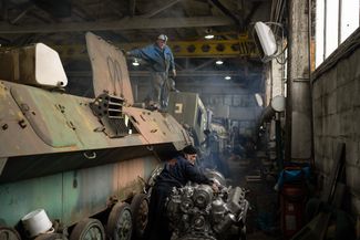 Механик ремонтирует двигатель украинского бронетранспортера