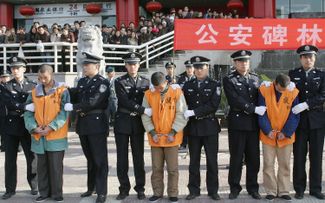 Китайские полицейские демонстрируют публике осужденных, часть из которых были приговорены к смертной казни. Сиань, 15 ноября 2004 года