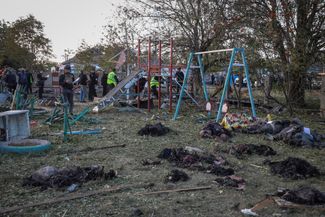 Тела погибших жителей Грозы на детской площадке возле сельского кафе. 5 октября 2023 года