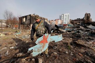 Военнослужащий теробороны Украины держит фрагмент российского боевого самолета Су-34 в Чернигове. 7 апреля Пентагон заявил, что в городе больше нет российских войск