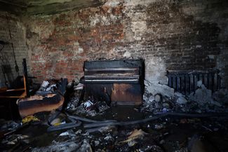 Сгоревшее пианино в квартире жилого дома, который был поврежден во время ракетного обстрела