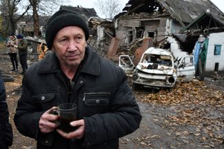 68-летний житель Покровска пьет чай рядом со своим разрушенным домом. 