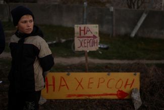 Владимир Чохон, житель села Киселевка, освобожденного ВСУ, стоит рядом с самодельным дорожным знаком, указывающим на Херсон. Кисилевка находится в 25 километрах от Херсона