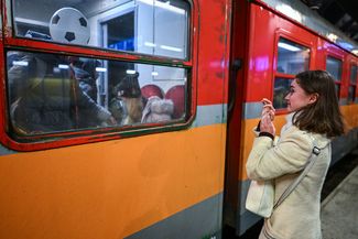 Женщина плачет, прощаясь с родственниками-беженцами из Украины, которые отправляются в гуманитарном поезда в Берлин. Краков, Польша, 13 марта 2022 года
