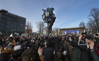 Полицейский пытается снять протестующих с фонаря на Пушкинской площади, 26 марта 2017 года