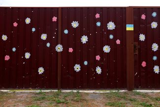 Цветы, нарисованные вокруг осколочных пробоин на воротах в Мощуне