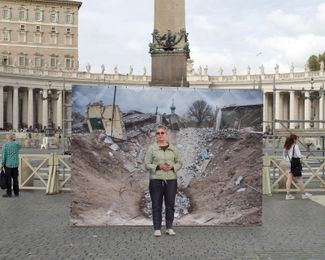 60-летняя дантистка Анна в Ватикане перед кадром французской фотожурналистки Лоранс Же, который она сделала в селе Яцковка Донецкой области, освобожденном ВСУ в сентябре 2022 года