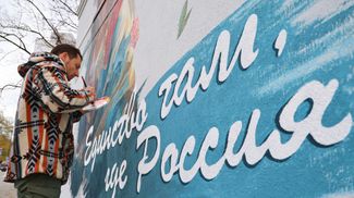 Художник Владислав Степной работает над муралом в центре Донецка в рамках подготовки к празднованию Дня народного единства