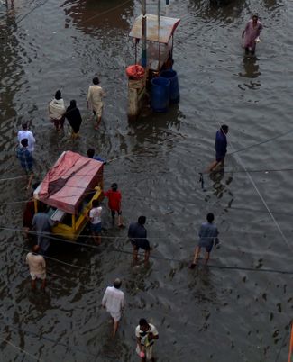 Жители Хайдарабада идут через затопленный участок<br>