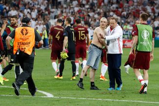 Леонид Слуцкий с болельщиком, выбежавшим на поле во время матча Англия — Россия на Евро-2016 в Марселе. 11 июня 2016 года