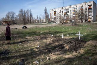 Могилы погибших жителей города Рубежное Луганской области во дворах жилых домов.