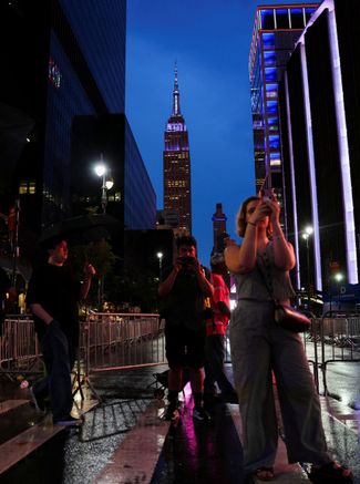 Passersby with the Empire State Building in the background. July 3, 2026