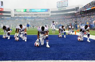 Игроки команды Buffalo Bills перед началом матча по американскому футболу протестуют против полицейского насилия в отношении чернокожих. Нью-Йорк, 29 октября