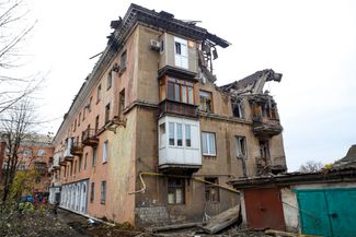 Спасатели (слева) работают у поврежденного в результате украинского обстрела здания в Макеевке. Город расположен к востоку от Донецка, он находится под контролем пророссийских сил с 2014 года