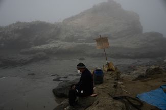 Рыбак Уолтер-де ла Круз сидит на пляже Каверо, загрязненном разлившейся нефтью, где рыбалка больше невозможна. Кальяо, Перу. 21 января 2022 года.