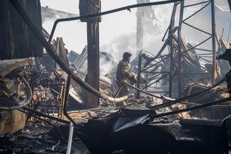 Спасатели разбирают завалы торгового центра после российского обстрела Никополя