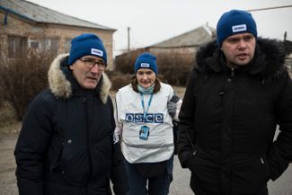Andrea Cellino (left) and other OSCE monitors verify a temporary truce they arranged in Trokhizbenka, Luhansk region. November 23, 2014. 