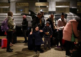 Беженцы, прибывшие из Львова, ждут на платформе железнодорожной станции