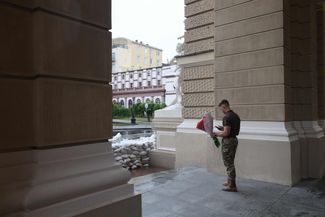 Украинский военнослужащий с букетом цветов перед одесским оперным театром