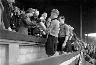 Принцесса Элизабет поздравляет капитана ФК «Вулверхэмптон Уондерерс» Билли Райта после финального матча Кубка Англии по футболу. 30 апреля 1949 года