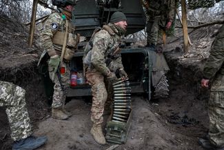 Бойцы ВСУ заряжают зенитную пушку