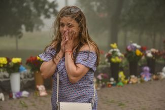 Плачущая женщина возле мемориала у разрушенного торгового центра «Амстор». 28 июня 2022 года