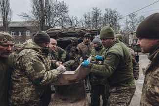 Украинские военные врачи переносят раненого бойца ВСУ в госпиталь