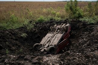 Уничтоженная легковая машина в поле под освобожденным от оккупации поселком Прудянка Харьковской области<br>
