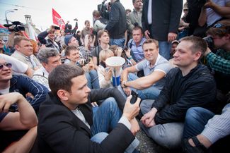 On May 6, 2012, Navalny helps stage a mass protest at Moscow’s Bolotnaya Square against Vladimir Putin’s re-election and return to the presidency. In this photo, Navalny joins two of the demonstration’s other leaders, Boris Nemtsov and Ilya Yashin, in staging a sit-in. The rally ends in clashes with the police and dozens of criminal cases alleging riots and violence against the police. These investigations later became known collectively as the “<a href="https://meduza.io/feature/2017/05/06/pyat-let-bolotnomu-delu-desyat-istoriy-ego-uchastnikov" target="_blank">Bolotnoye Delo</a>.”