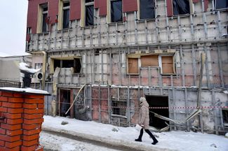 Жительница Белгорода идет мимо здания, поврежденного в результате обстрелов со стороны Украины. 10 января 2024 года