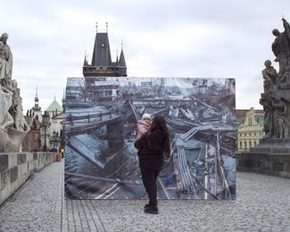 Two-year-old Alina is held by her mother in front of an image of a destroyed bridge in Irpin, Kyiv region. The photograph, taken by Mexican photojournalist Narciso Contreras, was placed on the Charles Bridge in Prague, Czechia.